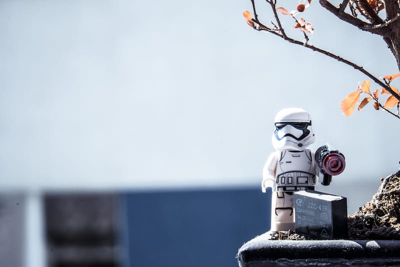 Lego trooper standing under a tree with a weapon